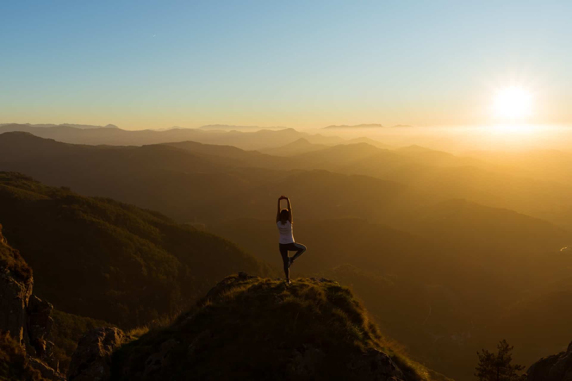 A woman doing yoga on a mountain