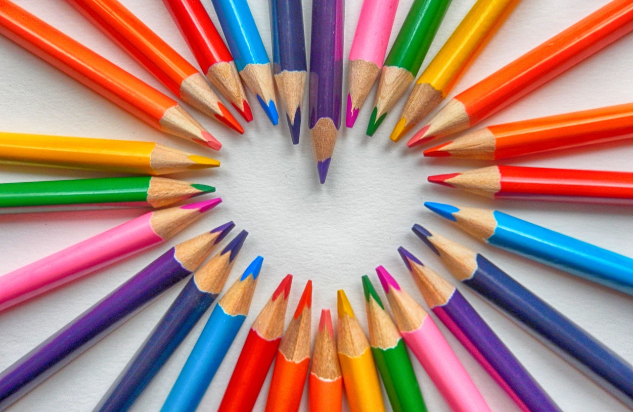 Colourful pencil crayons forming the shape of a heart