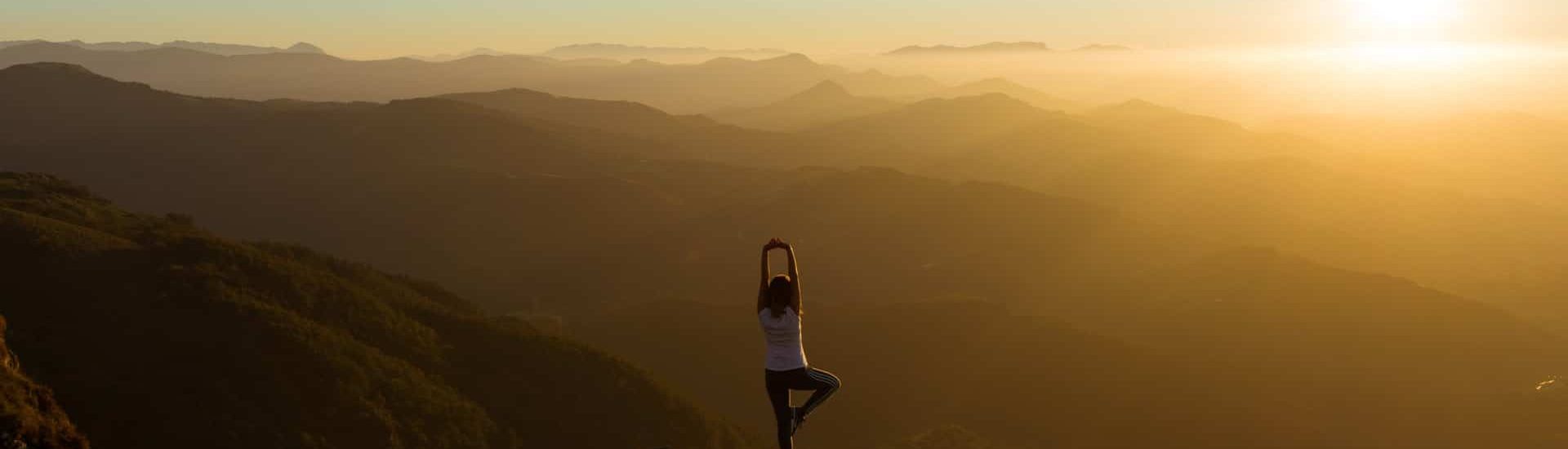 A woman doing yoga on a mountain